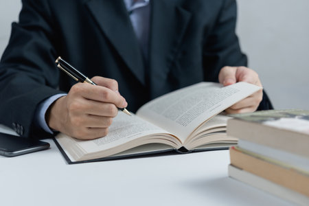 Businessperson reading and writing on book.education studying knowledge development and cognition learning concept.の写真素材