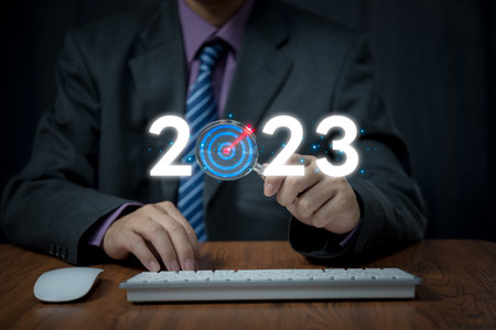 businessman holding magnifying glass to 2023 for preparation happy new year concept. new business in new years, start up, action plan and strategy in new business.の写真素材