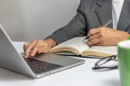 Woman hands with pen writing on notebook in the office.learning, education and work.writes goals, plans, make to do and wish list on desk.の写真素材