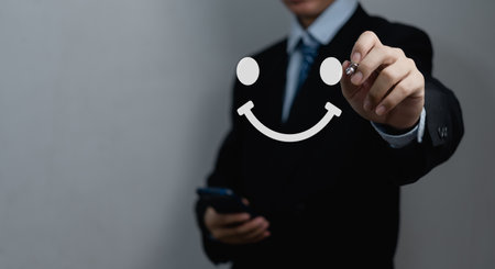 Businessman drawing a happy face smile face. Customer service experience, satisfaction survey, feedback and review concepts.の写真素材