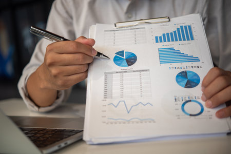 businessmen pen pointing to graphs and report on table, financial accounts, market economy.の写真素材