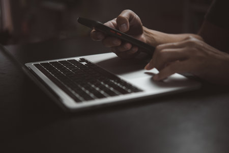 man using working searching information mobile smart phone and working on laptop compute.の写真素材