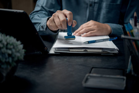 hand stamping with approved stamp on certificate document Contract Form Paper at desk, notary or...