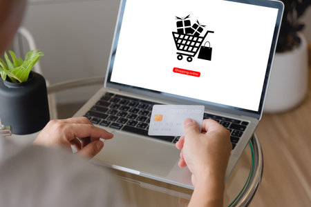 Hand holding credit card using laptop with shopping online application. concept marketing ecommerce and payment internet banking business.の写真素材