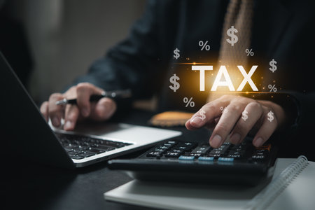 Businessman using calculation and laptop income tax online return form for payment. Financial research, government taxes icon virtual screen.の写真素材