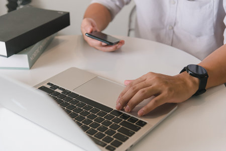 Man using touchscreen smartphone to stay connected, browse the internet, access information, and...