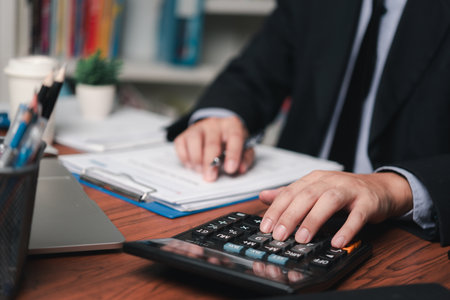 businessman working accountant document graph and chart on desk using calculator for calculate finance report in office.の写真素材