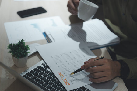 Business man hand writing schedule, checking event planning on calendar with laptop computer on...