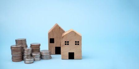 Stack coins with house model background. business finance investment and savings insurance home loan...