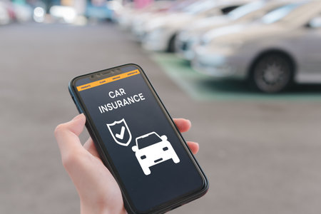 Hand using mobile phone device to access an online car insurance platform customers can compare quotes, With this innovative solution, file claims, and access roadside assistance right.の写真素材