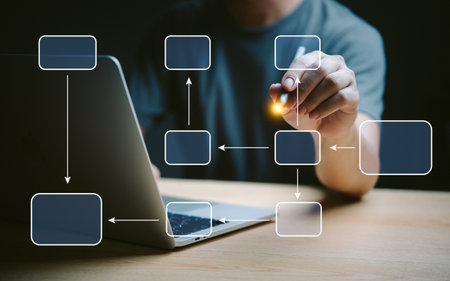 Hand drawing flowchart on laptop screen, indicating workflow, process management. Highlights planning, strategic development. Useful for business presentations, project management.の写真素材