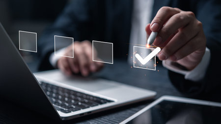 A businessman interacts with a digital checklist on a laptop, symbolizing task management and...