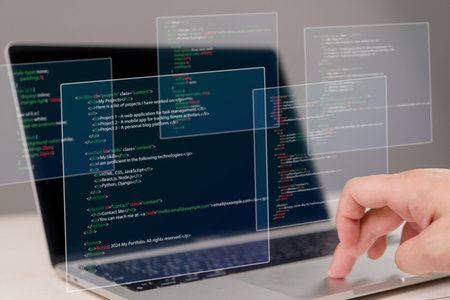 Hands typing on laptop with programming code on screen, representing software development. Perfect for coding, IT solutions, digital technology, web applications.の写真素材