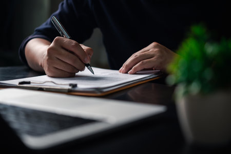 Business person Writing contract law and paper work for business and finance, write document, complete job application forms, contract real estate and insurance concept.の写真素材