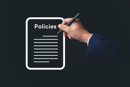 Hand holding pen to sign business policy document. Ideal for legal agreements, document review, office administration, and corporate law visuals.の写真素材