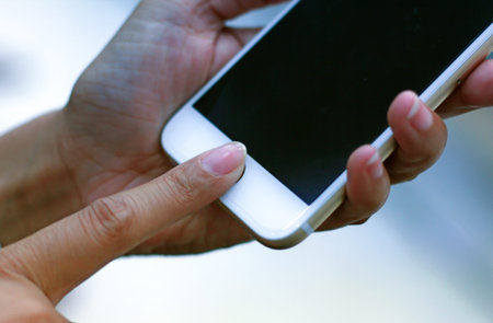 Women are scanned fingerprint or touch id to activate Smartphone.