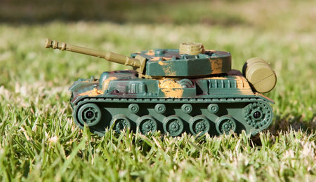 Plastic toy tank on grass in sunlightの写真素材