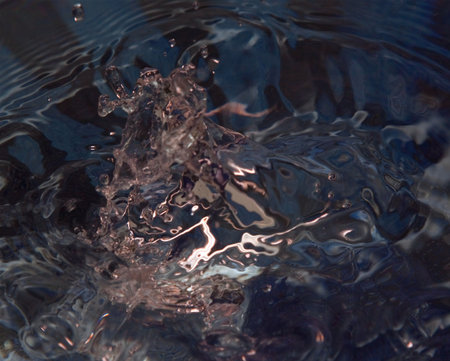 Water drop on blue surface, with the spalsh frozen in time, interesting pattern ideal for a...
