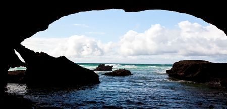 Cave in the ocean looking out into the sunshineの写真素材