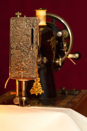 Old style sewing machine, sewing a white cloth