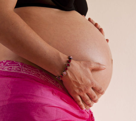 Pregnant woman holding her tummy lovingly