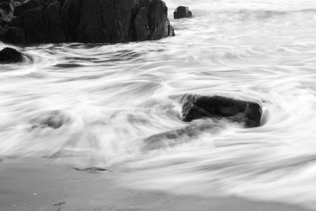 Wave withdrawing making patterns with slow shutter speedの写真素材