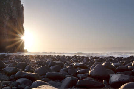 Sunrise landscape with rocks cliffs and ocean and blue skyの写真素材