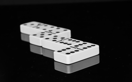 Dominoes on black shining surface with reflectionの写真素材