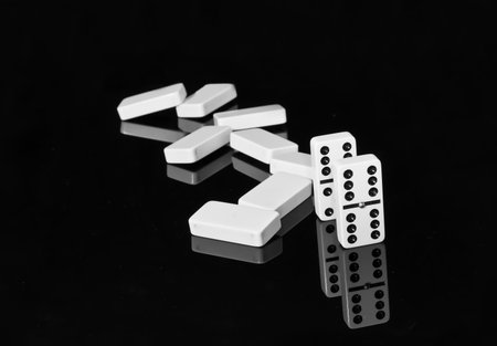 Dominoes on black shining surface with reflection