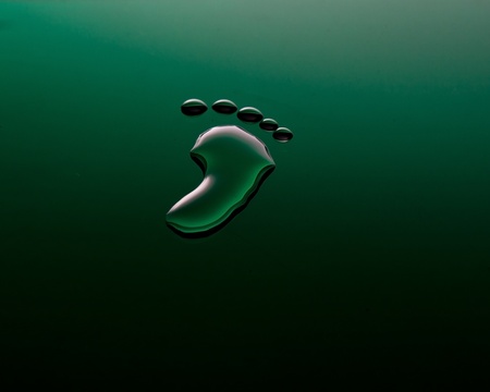One footprint made of water on a bright green surfaceの写真素材