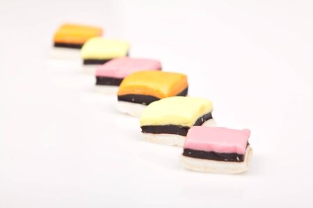 Pink, yellow and orange colored allsorts packed in a rowのeditorial素材