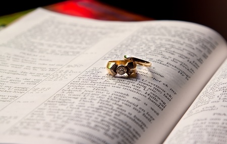 Close up of wedding rings lying on an open Bibleの写真素材