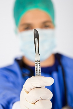 Female cardiac surgeon with mask and scalpelの写真素材
