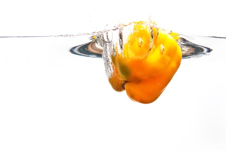 Yellow pepper falling into water white splash movementの写真素材