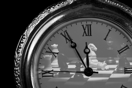 Pocket watch with chess pieces on board check mateの写真素材