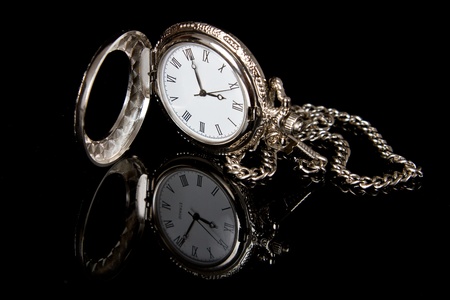 Pocket watch reflection on black shiny surface detailの写真素材