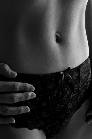 Woman in black underwear stand against wall closup black and whiteの写真素材