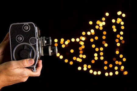 Old movie camera taking photo of bokeh on black background
