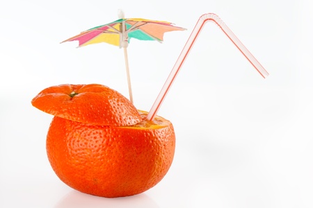 Orange sliced open with straw and umbrella ready to drinkの写真素材