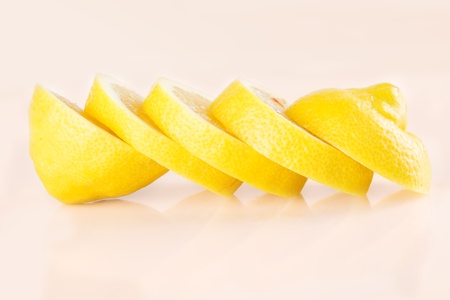 Row of juicy yellow lemon sliced wheels closeupの写真素材