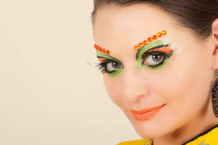 Lovely brunette woman portrait with creative make-up and orange spotsの写真素材