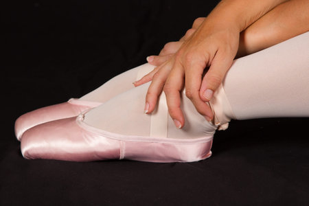 Female dancer sit on floor looking sad in pink tutu and slippers