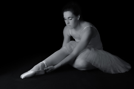 Female dancer sit on floor looking sad in artistic conversion black and whiteの写真素材