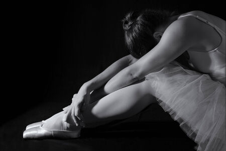 Female dancer sit on floor looking sad in artistic conversion black and whiteの写真素材