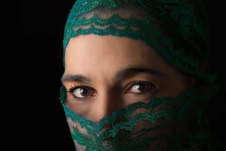 Middle Eastern woman portrait looking sad with a green hijab artistic conversionの写真素材