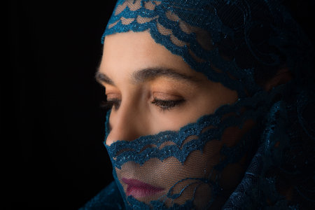 Middle Eastern woman portrait looking sad with a blue hijab artistic conversion