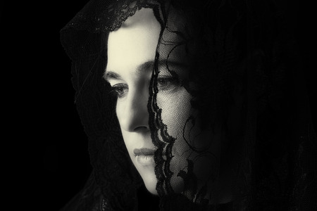 Middle Eastern woman portrait looking sad with a black hijab artistic conversionの写真素材