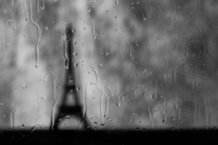 Eiffel tower seen through a wet window in rain stormの写真素材