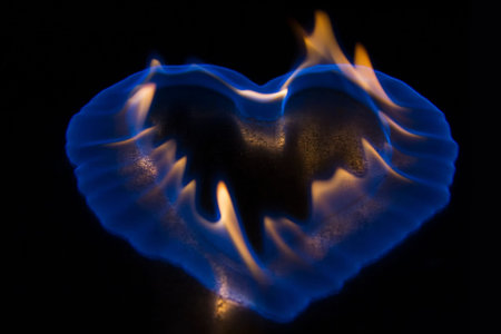 Blue flame in the shape of a heart burning on shiny surfaceの写真素材