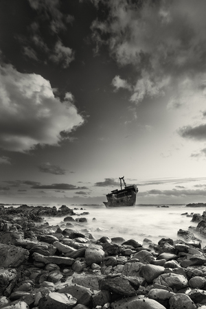 Old shipwreck long exposure on the rocks at sunset artistic conversionの写真素材